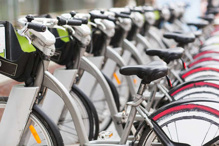 Row of parked vintage bicycles bikes for rent on sidewalk.の写真素材