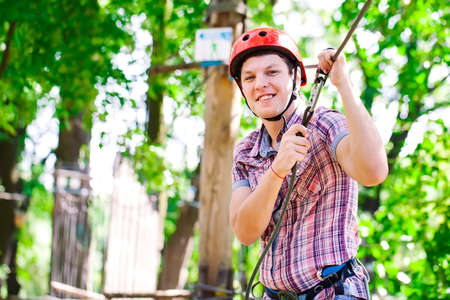 adventure climbing high wire park - people on course in mountain helmet and safety equipmentの写真素材