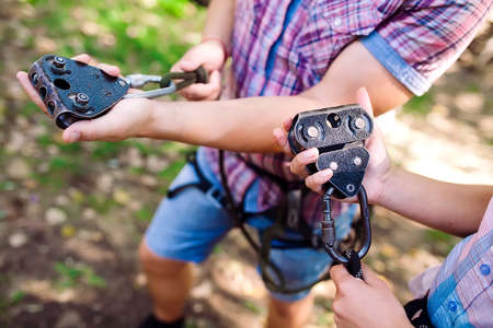adventure climbing high wire park - people on course in mountain helmet and safety equipmentの写真素材