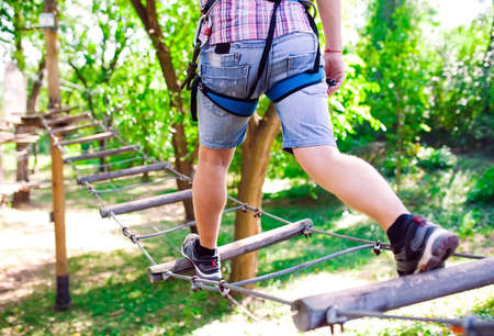 adventure climbing high wire park - people on course in mountain helmet and safety equipmentの写真素材