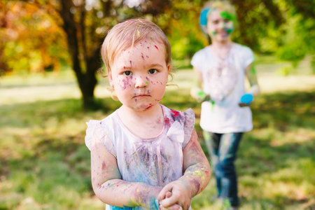 Portrait of a cute girl painted in the colors of Holi festival.の写真素材