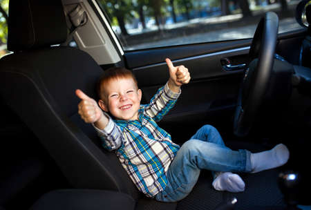 Cute little boy smiling and driving fathers carの写真素材
