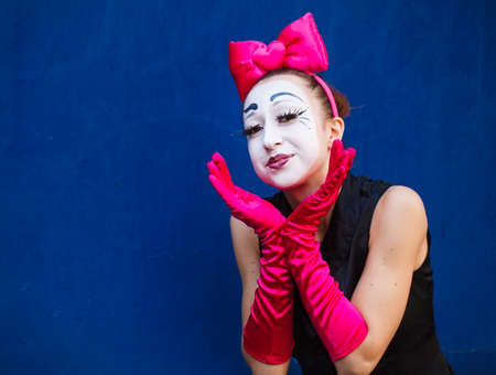 Mime portrait near a blue wall. Isolated on blue backgroundの写真素材