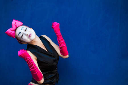 Mime portrait near a blue wall. Isolated on blue backgroundの写真素材