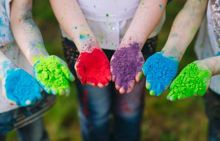Hands Palms of young people covered in purple, yellow, red, blue Holi festival colors isolatedの写真素材
