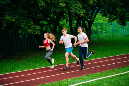 Running young people at a stadium trackの写真素材