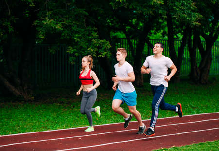Running young people at a stadium trackの写真素材
