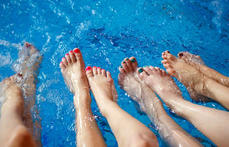 Girls relaxing in swimming pool. Close up female legs.の写真素材