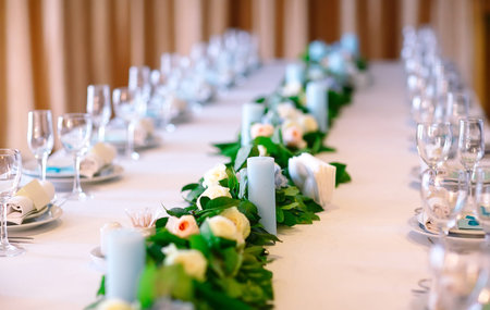 Wedding table settings. Empty plates and glasses on a white tablecloth.