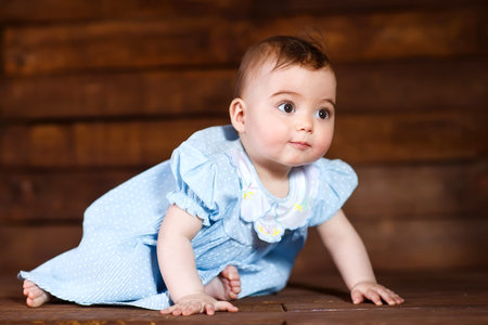 Cute little girl on a wooden background.