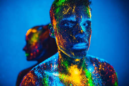People are colored fluorescent powder. a pair of lovers dancing at a disco.の写真素材