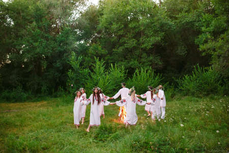 Midsummer. Young people in Slavic clothes revolve around a fire in the Midsummerの写真素材