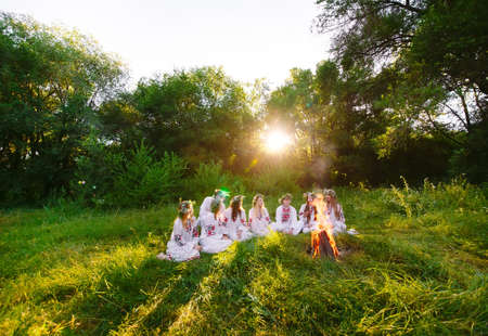 Midsummer. Group of young people of Slavic appearance are sitting around a campfire.の写真素材