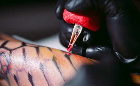 Professional tattoo artist makes a tattoo on a young girls hand.