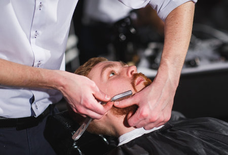 Confident man visiting hairstylist in barber shop.
