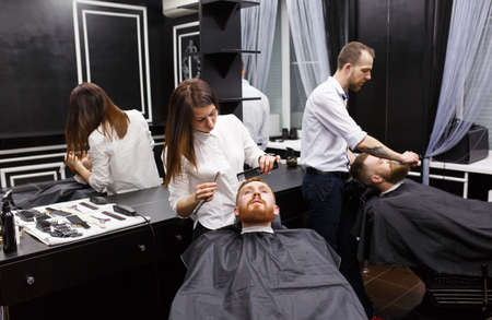 Confident mans visiting hairstylists in barber shop.の写真素材