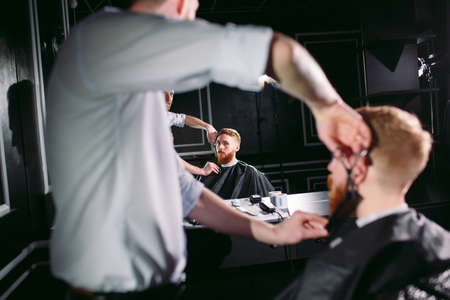 Confident man visiting hairstylist in barber shop.の写真素材