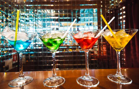 Multicolored cocktails at the bar. bartender show