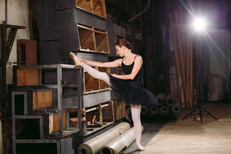 Young ballerina in black dress trains behind the scenes.の写真素材