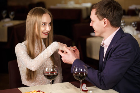 Marriage proposal at a restaurant. Beautiful young couple in a cafe.