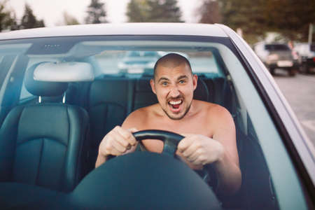 Naked man in the car is in a traffic jam.の写真素材