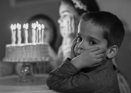 Childrens birthday. Children near a birthday cake with candlesの写真素材