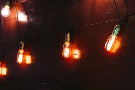 Vintage incandescent Edison type bulbs on wooden wallの写真素材
