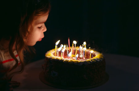 Birthday. A little sweet girl blows out candles on the stoke