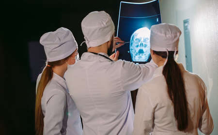 Doctors watching x-ray of patient near the hospital room.の写真素材