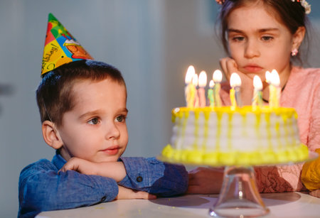 Childrens birthday. Children near a birthday cake with candles