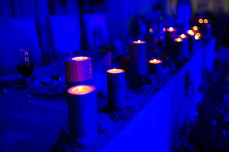 Wedding table setting with burning candles on the tableの写真素材