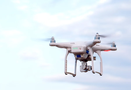 Quadcopter drone with the camera against the blue sky.
