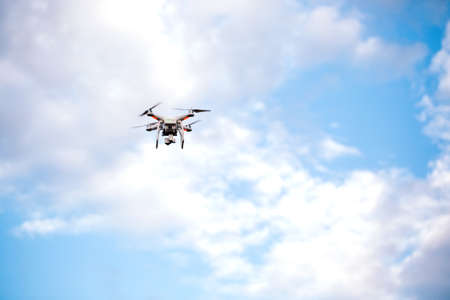 Quadcopter drone with the camera against the blue sky.の写真素材