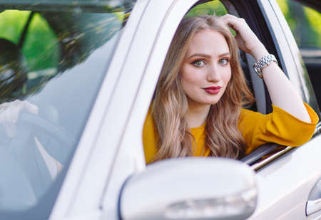 A young beautiful girl is driving a car.の写真素材