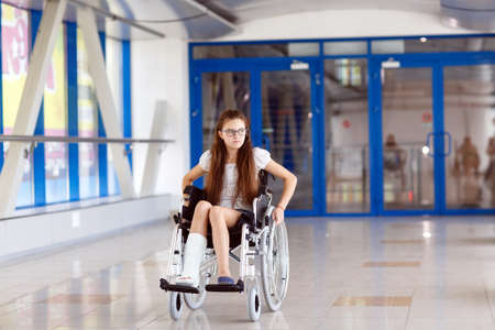 A young girl in a wheelchair is standing in the corridor of the hospital.の写真素材
