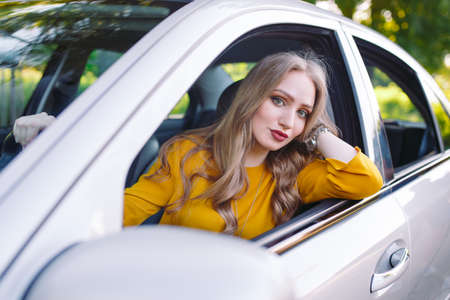 A young beautiful girl is driving a car.の写真素材