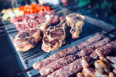 Large pieces of pickled meat on a grid in a restaurant. Mixed grilled meatsの写真素材