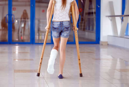 A young girl is on crutches in the corridor of the hospital.の写真素材