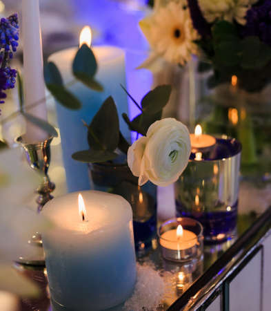 Candles and flowers on a table in the eveningの写真素材