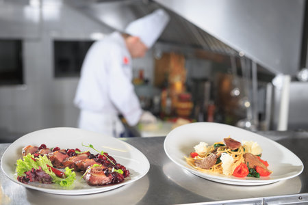 the distribution table in the kitchen of the restaurant. the chef prepares a meal on the background...
