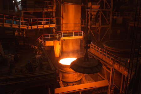 Melting of metal in a steel plant. High temperature in the melting furnace. Metallurgical industry. Factory for the manufacture of metal pipes. Bucket for feeding metal into molds.の写真素材