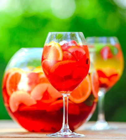 Summer cocktail. Fruit cocktail on green background. Citrus fruits, berries, strawberries, blueberries, mint, iceの写真素材