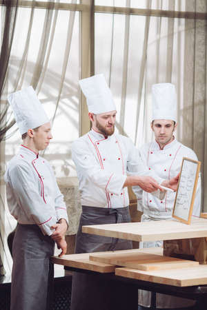 Head Chef and his staff in kitchen. interacting to in commercial kitchenの写真素材
