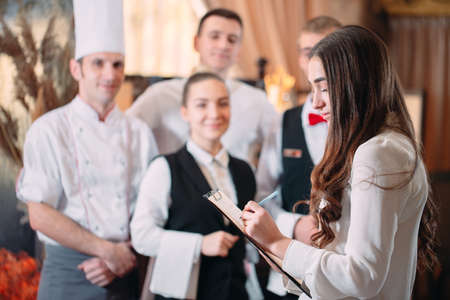 restaurant manager and his staff in kitchen. interacting to head chef in commercial kitchen.の写真素材