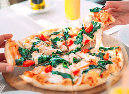 Eating Pizza. Hands close-up take pieces of pizza.の写真素材