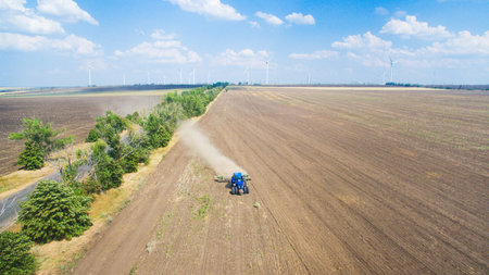 A tractor plowing and sowing in the field