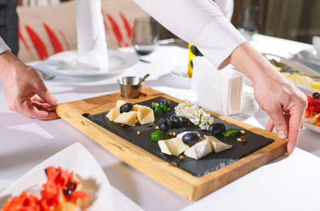 Waiter serving table in the restaurant preparing to receive guests.