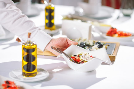 Waiter serving table in the restaurant preparing to receive guests