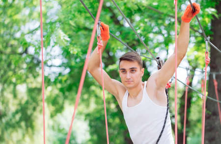 Man spend their leisure time in a ropes course. Man engaged in rope park.の写真素材
