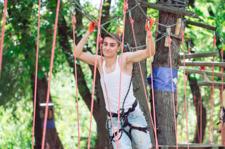 Man spend their leisure time in a ropes course. Man engaged in rope park.の写真素材
